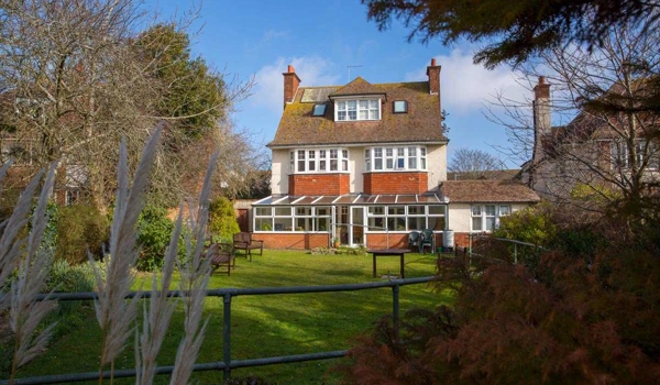 Back exterior of Lade House leading onto large sunny garden where residents can while away the hours in the sun